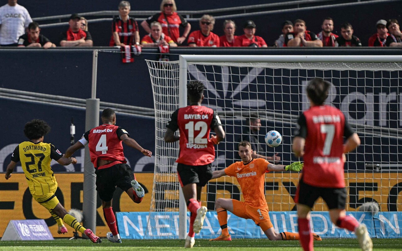 Adeyemi finaliza na saída do goleiro do Bayer Leverkusen (Foto: Ina Fassbender / AFP)