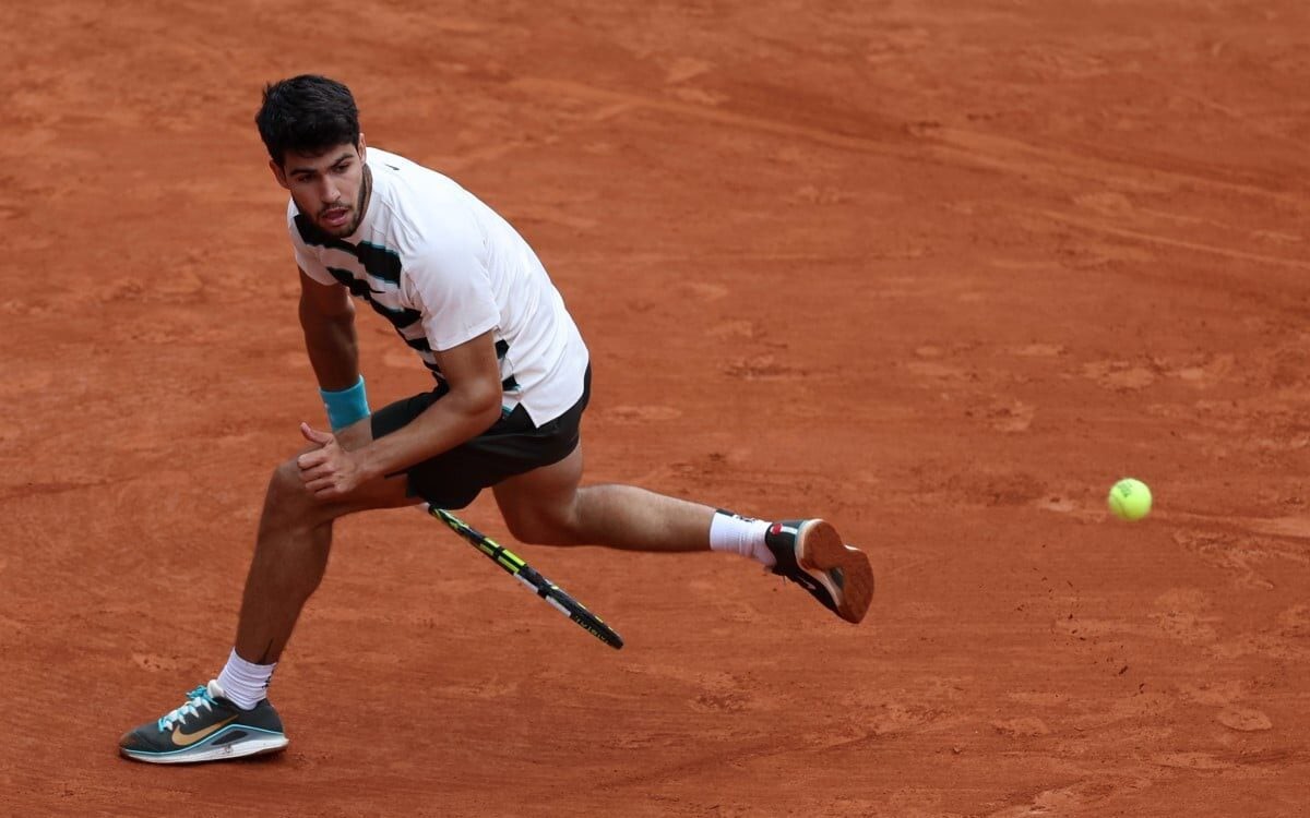O espanhol Carlos Alcaraz acerta uma grand-willy na vitória sobre Giulio Zeppieri em Roland Garros (Foto: Franck FIFE / AFP)