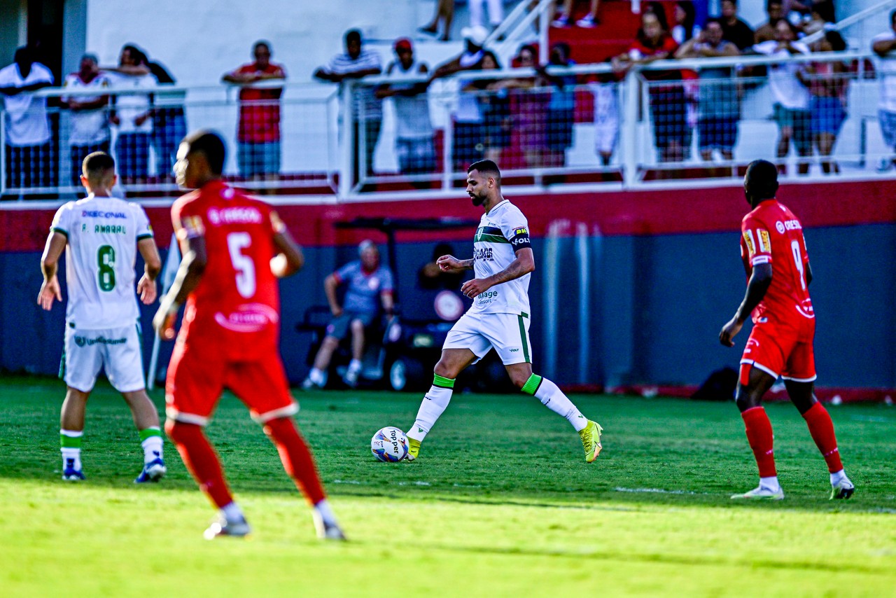 Observado por Marlon (à esquerda), Lucão domina a bola durante partida do Coelho contra o Tombense, pelo Mineiro