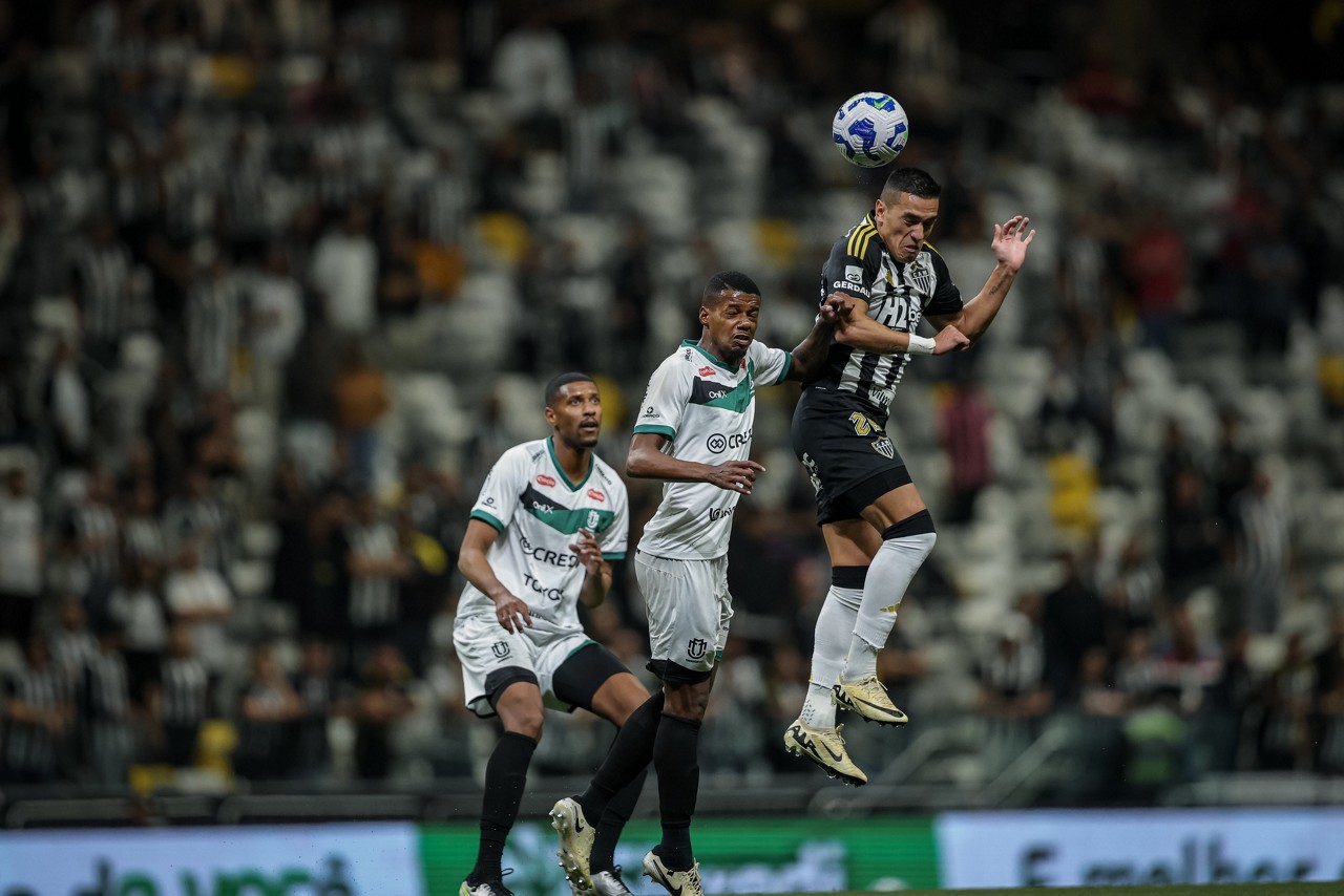 Cuello salta para tentar disputar a bola com defensor do Maringá durante partida disputada na Arena MRV