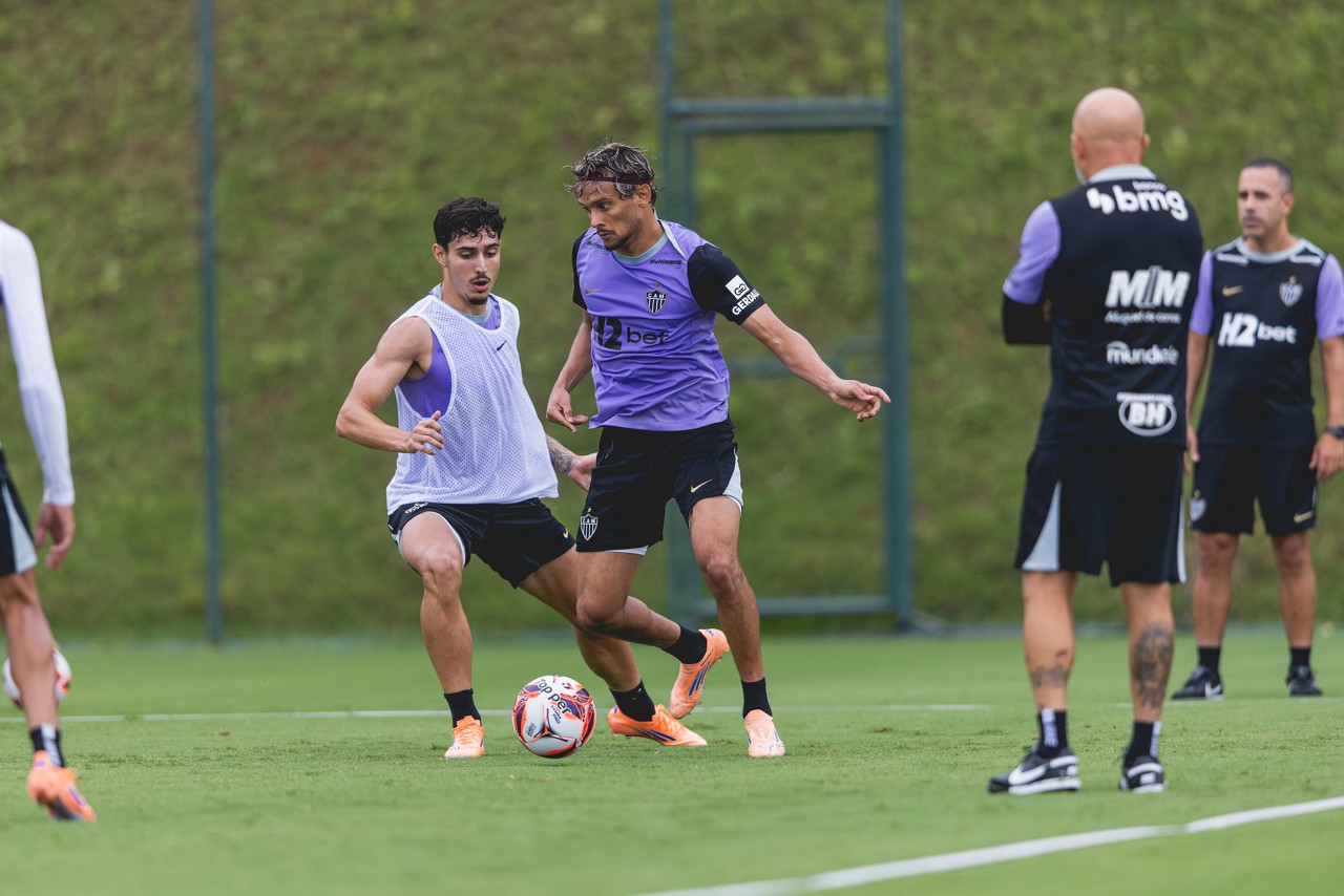Observado de perto por Sampaoli, Scarpa tenta passar pela marcação de Cadu durante treino na Cidade do Galo