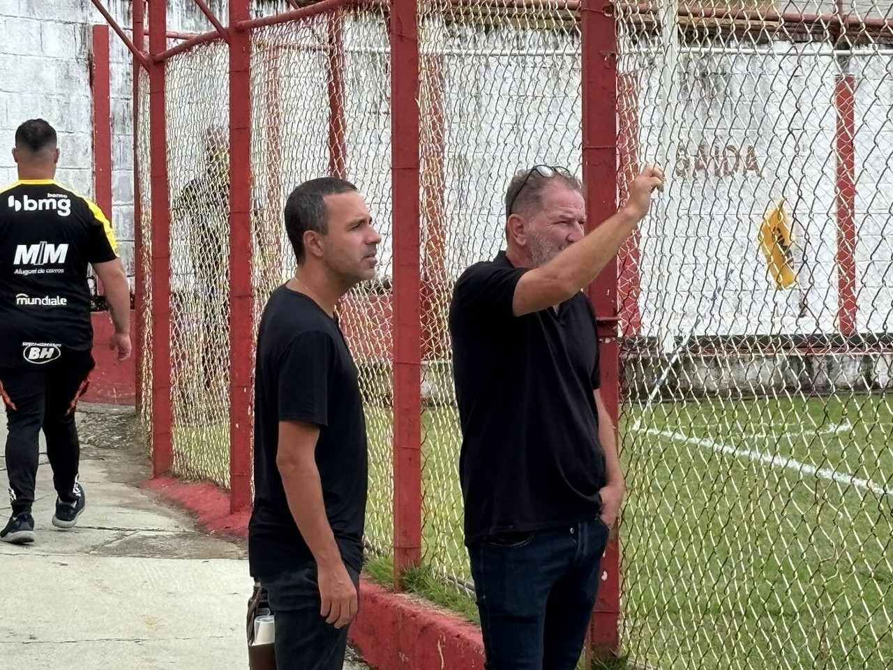 Lucas Gonçalves (esq.) e Cuquinha, que é irmão e auxiliar de Cuca, acompanham jogo-treino em Nova Lima, na região metropolitana de BH