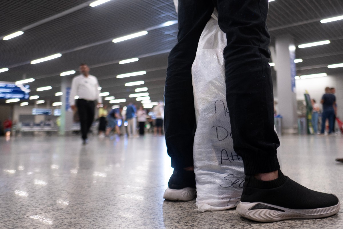 A man deported from US arrives at Confins International Airport in Confins, Minas Gerais state, Brazil on January 25, 2025. Brazil on January 25 condemned the "disregard for fundamental rights" of nearly 80 Brazilian illegal migrants deported from the US who were handcuffed during the journey. The plane landed in Manaus due to technical problems. (Photo by Douglas MAGNO / AFP)