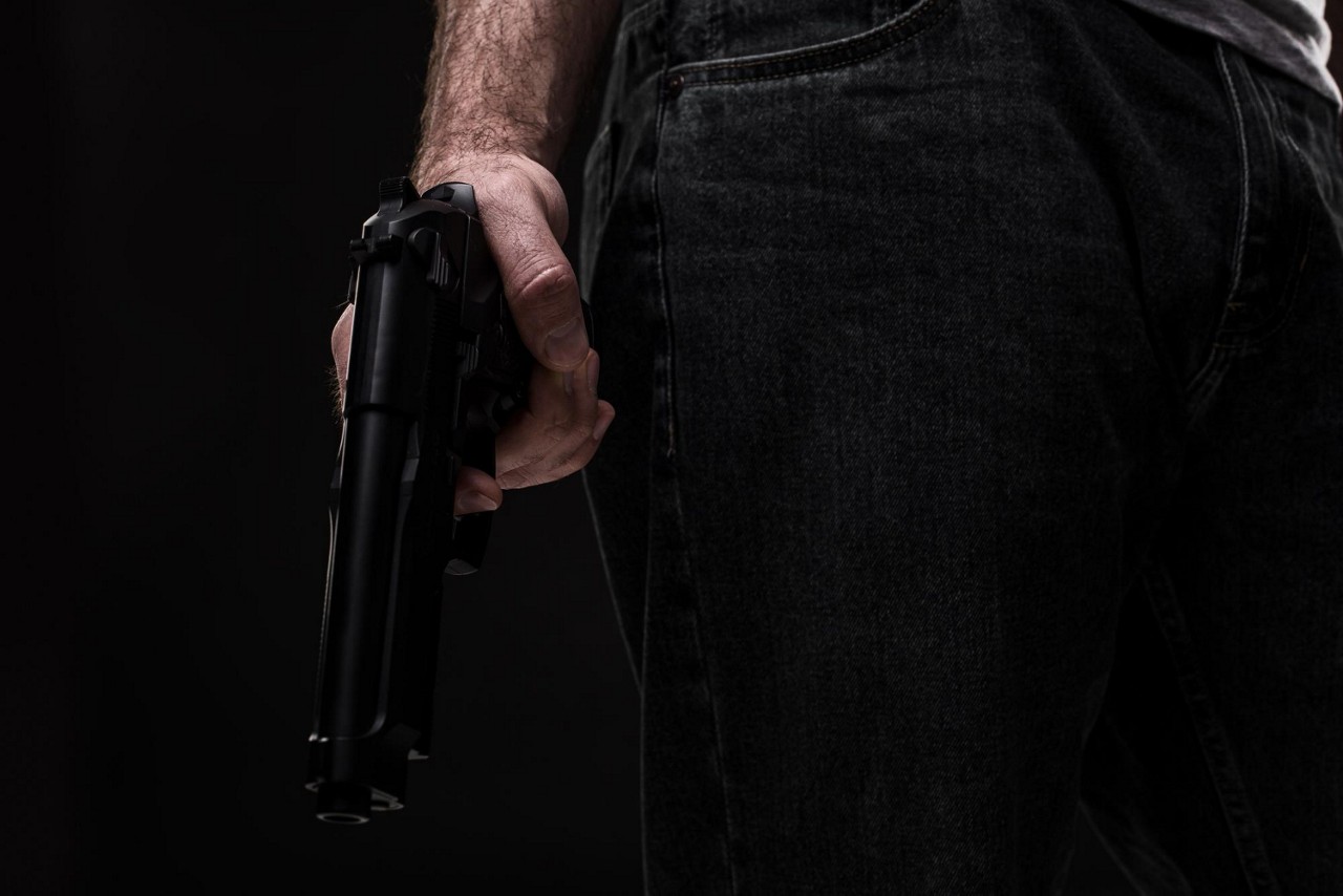 Imagem meramente ilustrativa de homem segurando uma arma