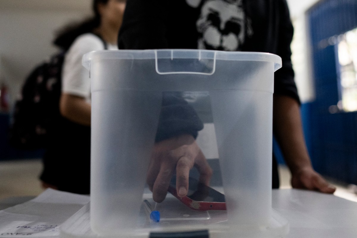Um estudante pega seu celular de uma caixa numa escola pública do Rio de Janeiro
