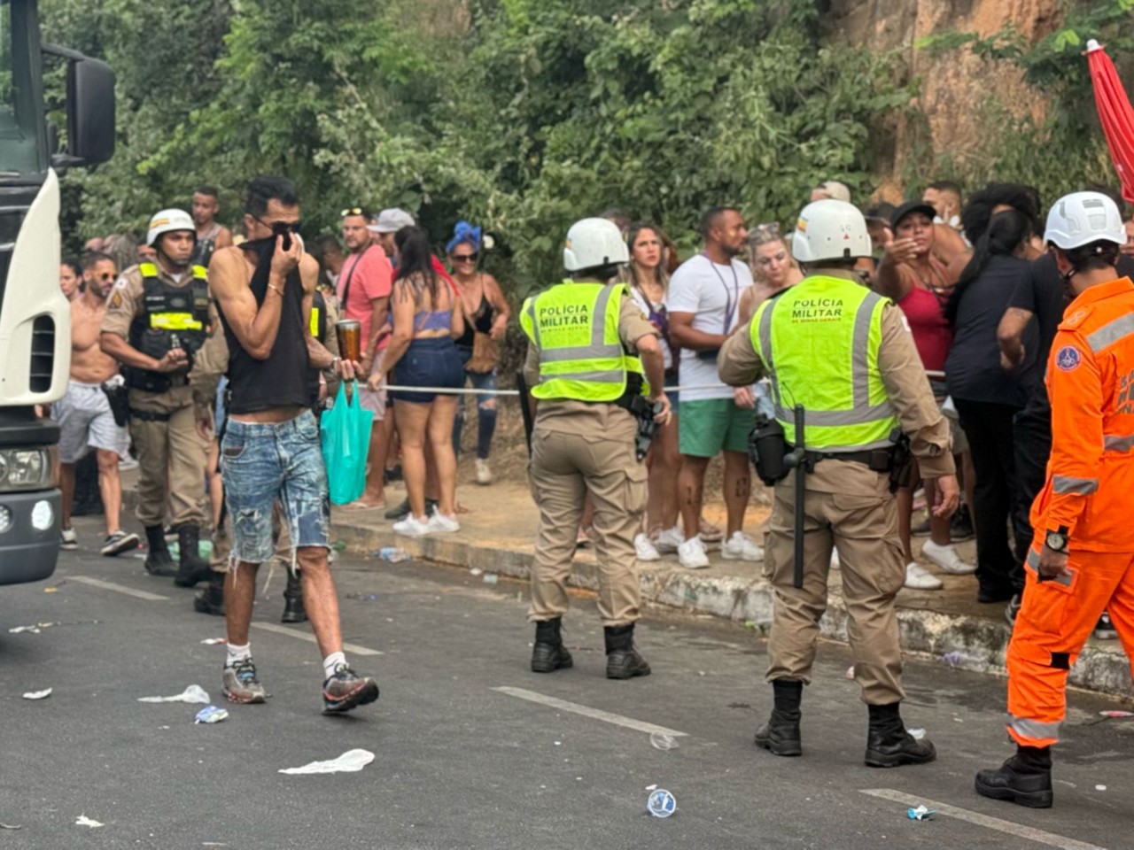 Folião cobre o nariz e a boca após PM jogar gás de pimenta em bloco de carnaval