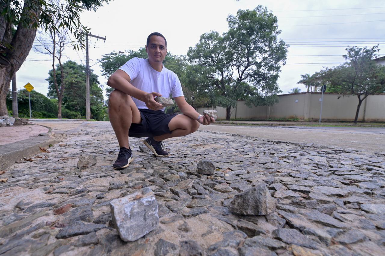 Advogado Rayan, de 32 anos, mostra algumas das diversas pedras soltas na avenida