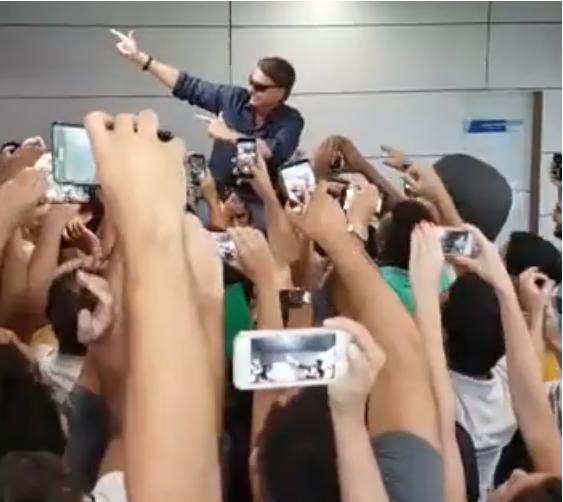 Deputado Jair Bolsonaro é recepcionado por dezenas de seguidores em Confins