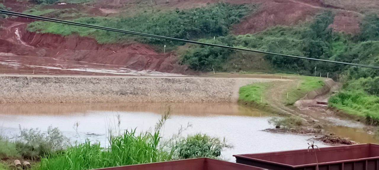 Imagem mostra área alagada entre o dique da mineradora e trilhos de trem