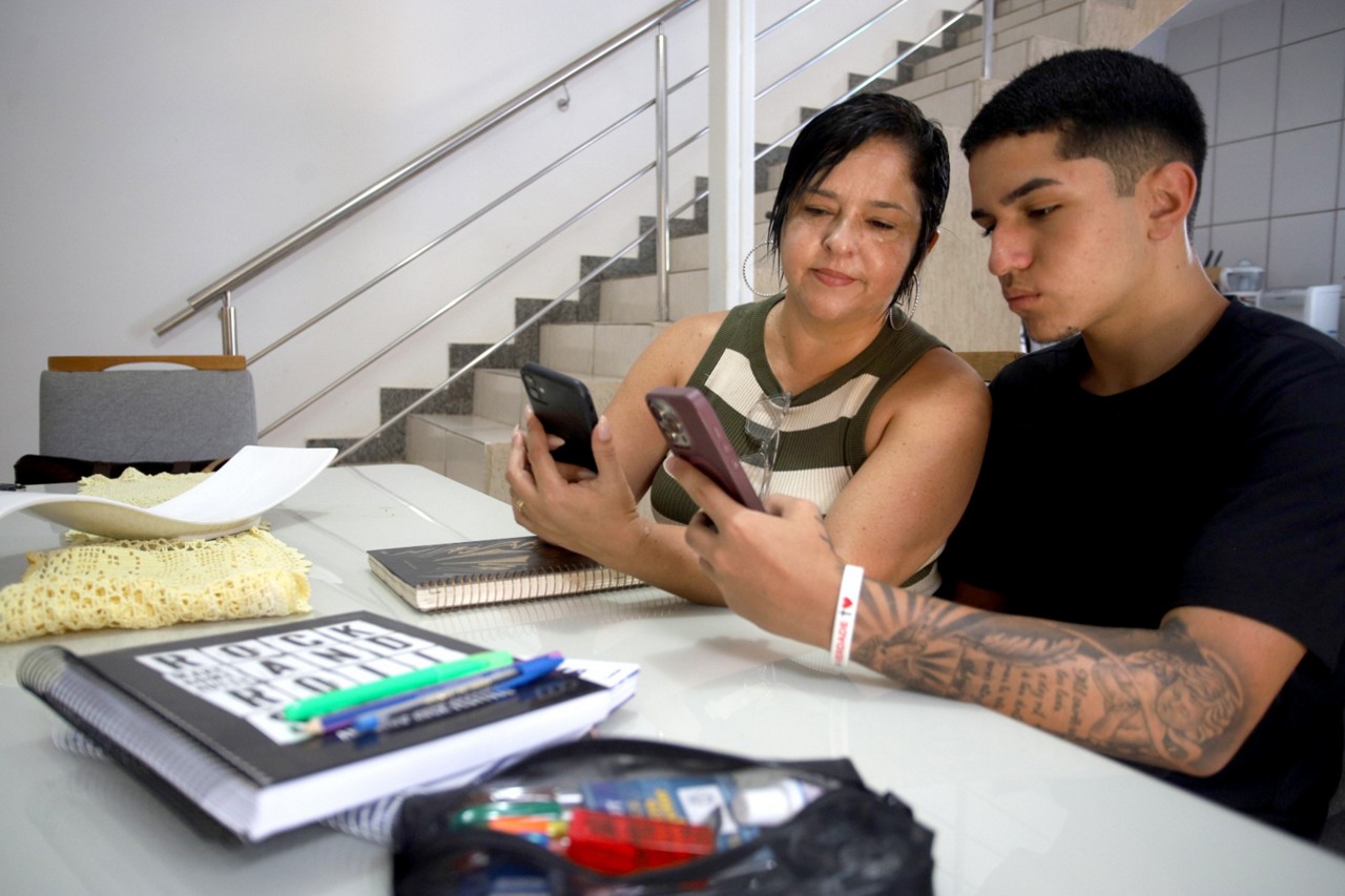 Anelísia Geralda Santos com filho Arthur Santos 16 anos. Ela é contra a proibição de celular nas escolas, pois não vai poder conversar com o adolescente durante os intervalos. 
