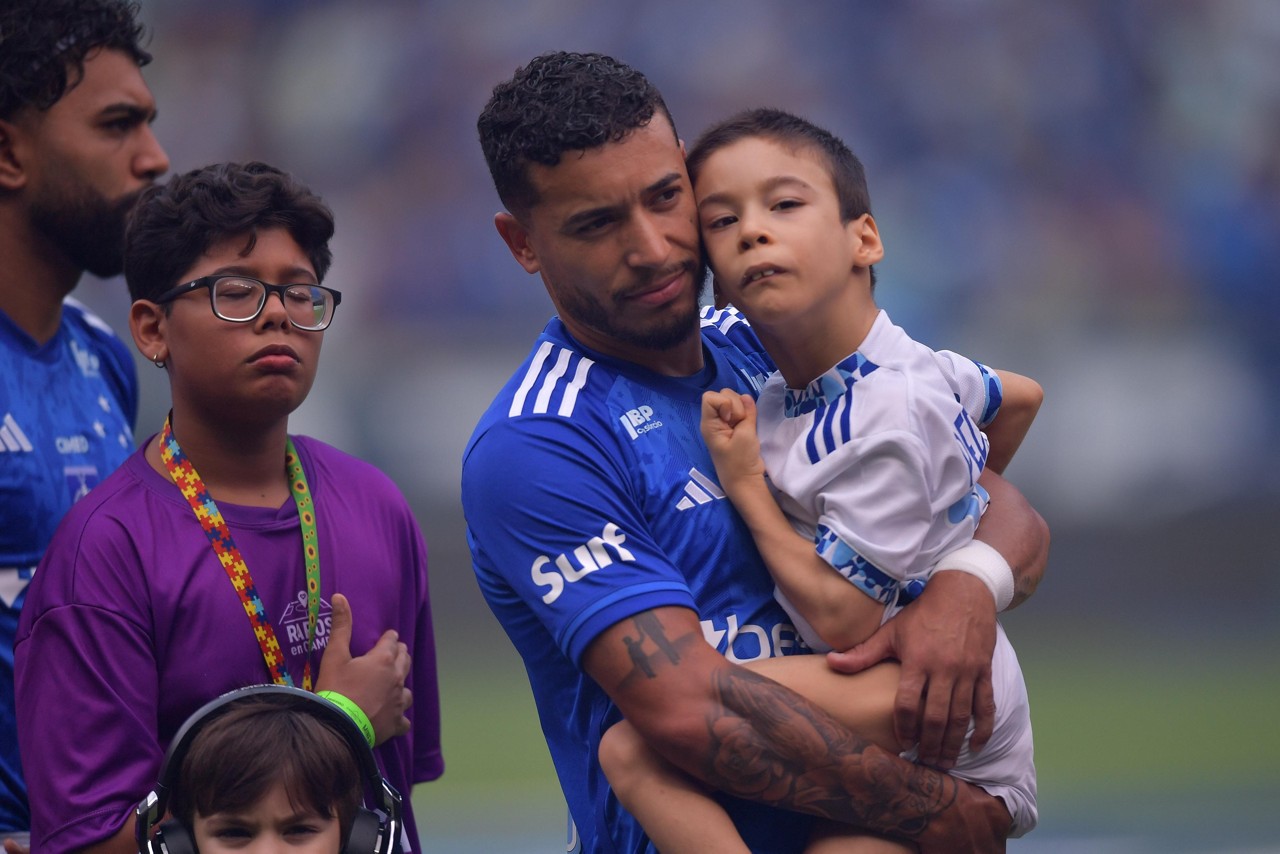 William carrega o filho Pedrinho antes do início da partida, dentro da Campanha Raros no Campo
