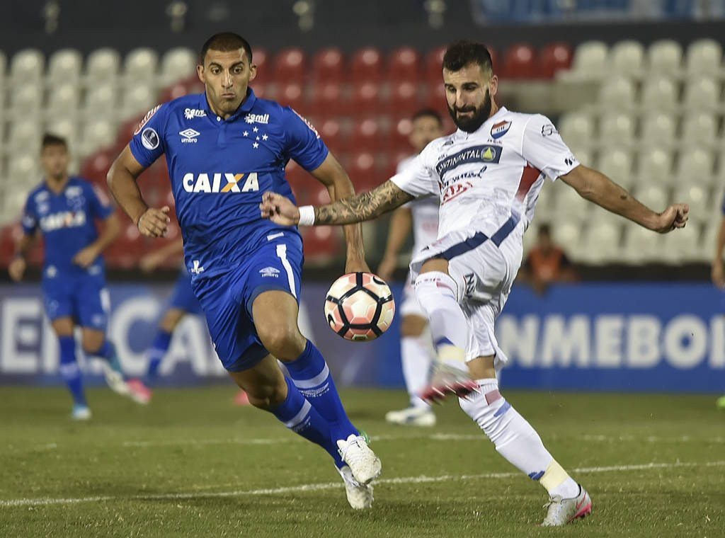 Atacante Ramon Ábila, do Cruzeiro, disputa bola com jogador do Nacional do Paraguai