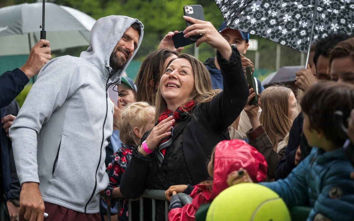Djokovic posa para selfie com fã em Genebra (Foto: FABRICE COFFRINI / AFP)
