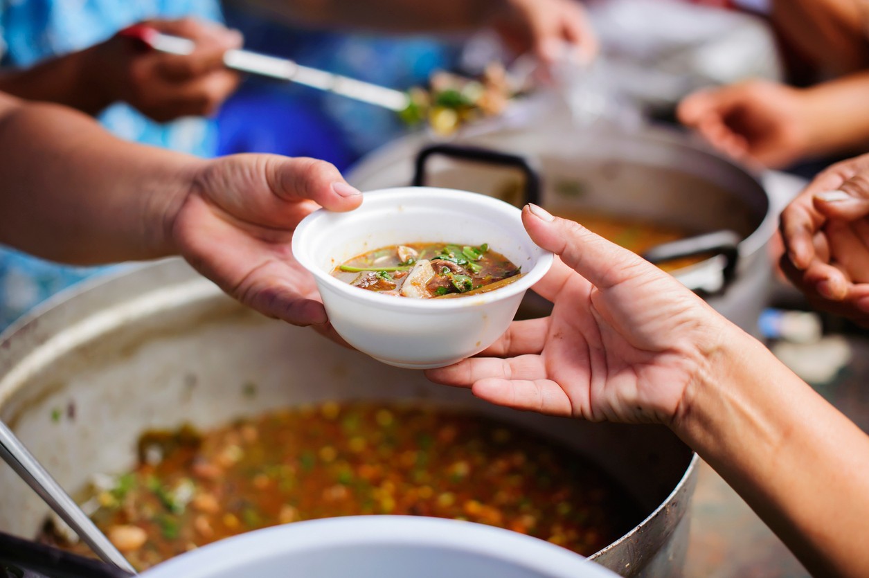 Homeless people are helped with food relief, famine relief : volunteers giving food to poor people in desperate need : The concept of food sharing Help solve Hunger for the homeless