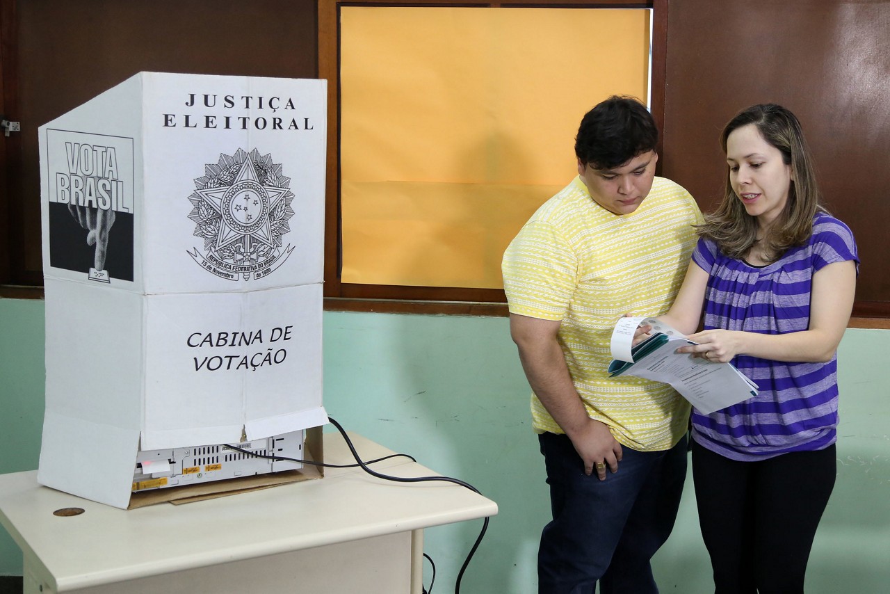 Mesário ajudando eleitor nas eleições 