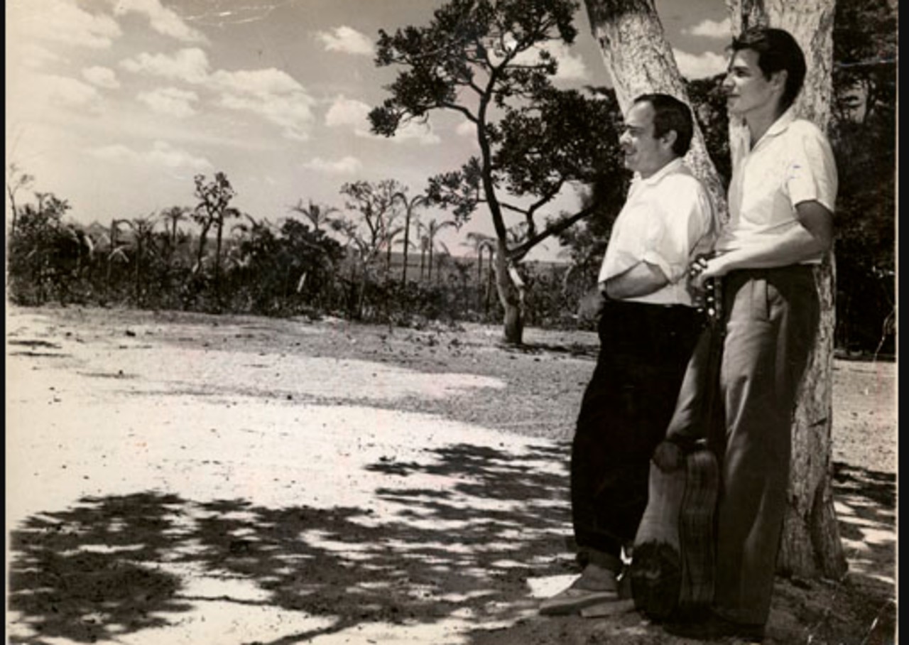 Tom Jobim com violão ao lado de Vinicius de Moraes, na região onde a nova capital federal estava sendo erguida, próximo ao Museu do Catetinho, a primeira residência presidencial de Brasília