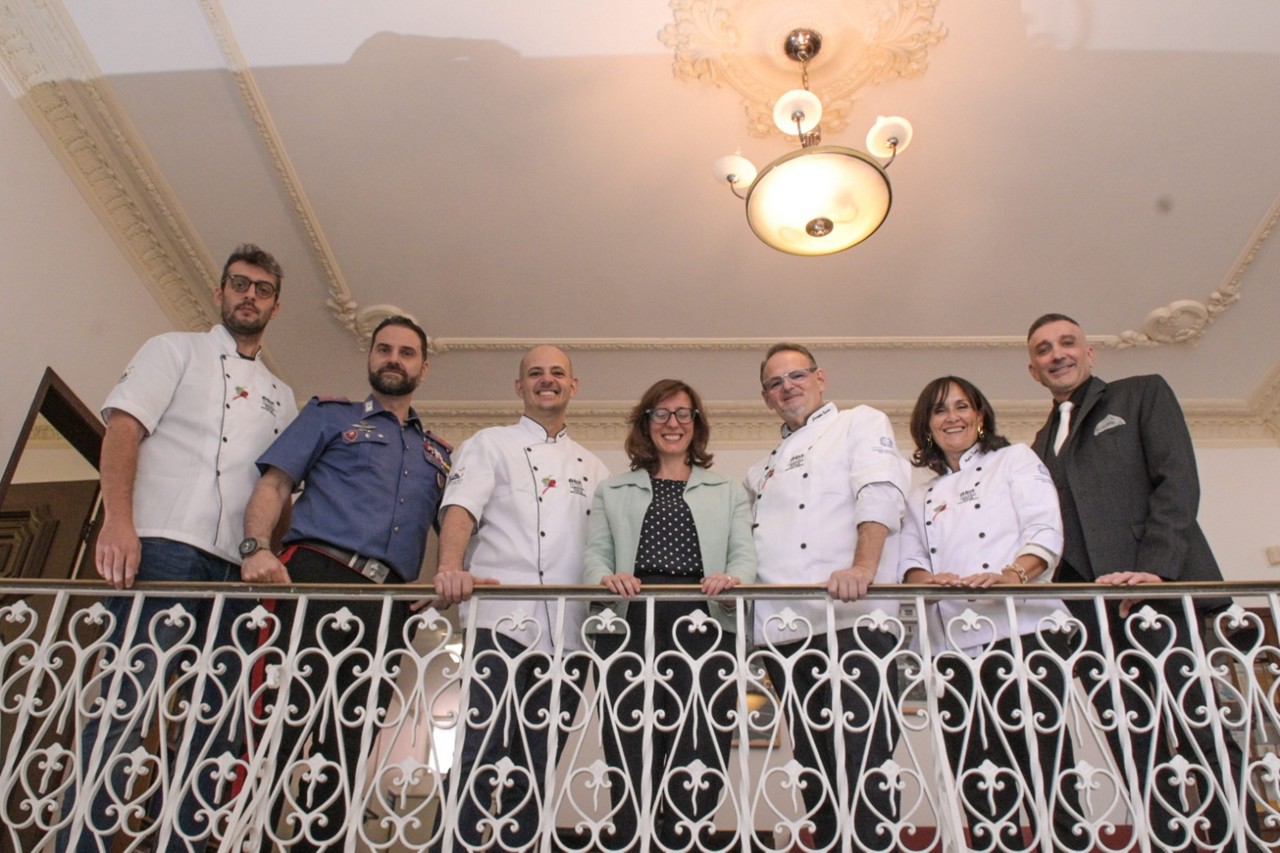 Ao centro, Nicoletta Gomiero, Cônsul Geral da Itália em Belo Horizonte; em volta dela chefs italianos que vão participar do fHist, vestindo uniformes brancos, e agentes do consulado
