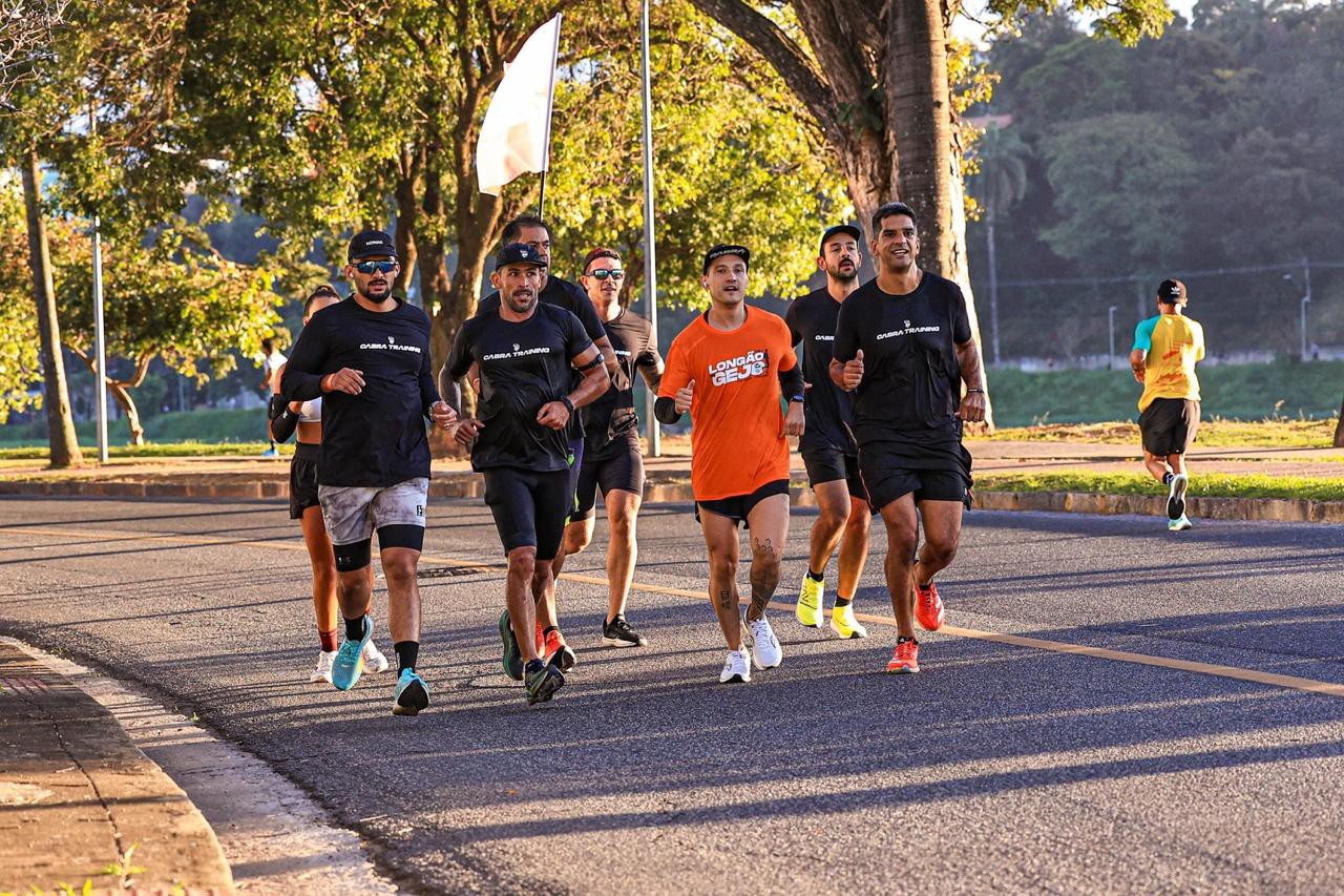 Georginton Oliveira, de camisa laranja, correndo ao lado dos amigos na Lagoa da Pampulha