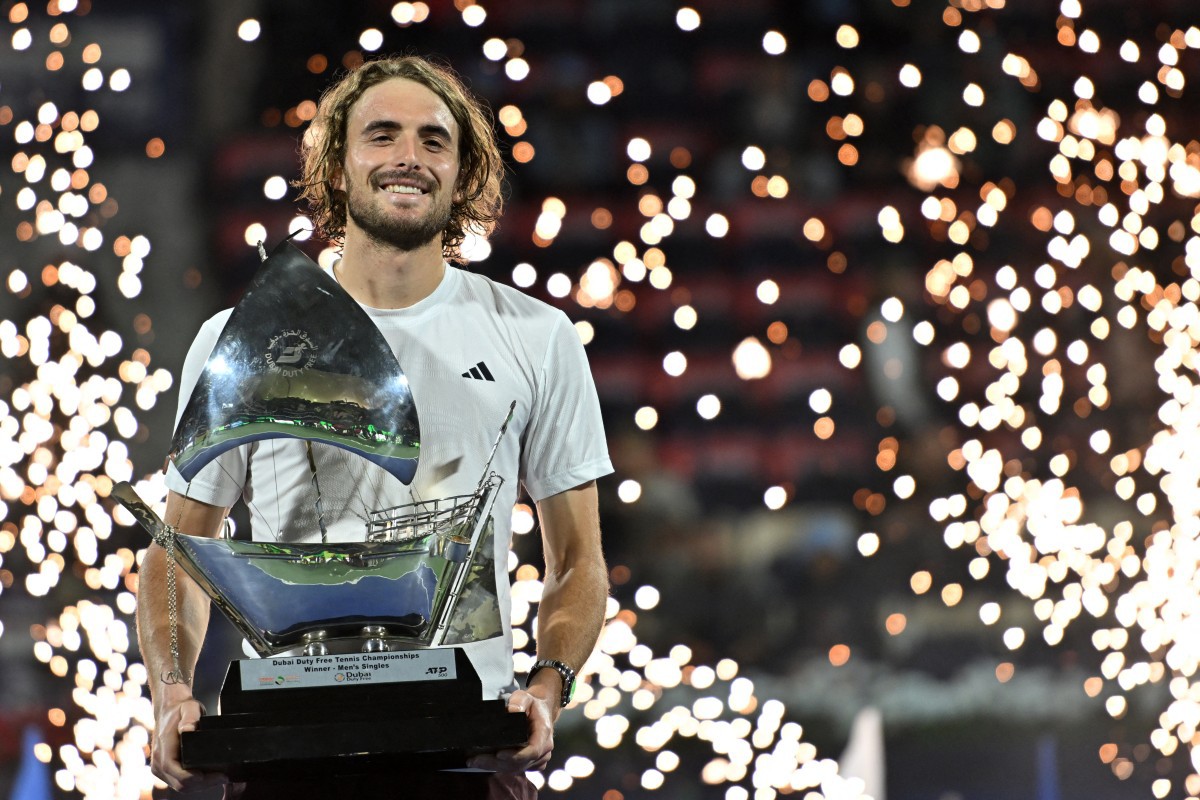 Greece's Stefanos Tsitsipas poses with the trophy on the podium after winning the final match of the ATP Dubai Duty Free Tennis Championship in Dubai on March 1, 2025. (Photo by Ryan Lim / AFP)