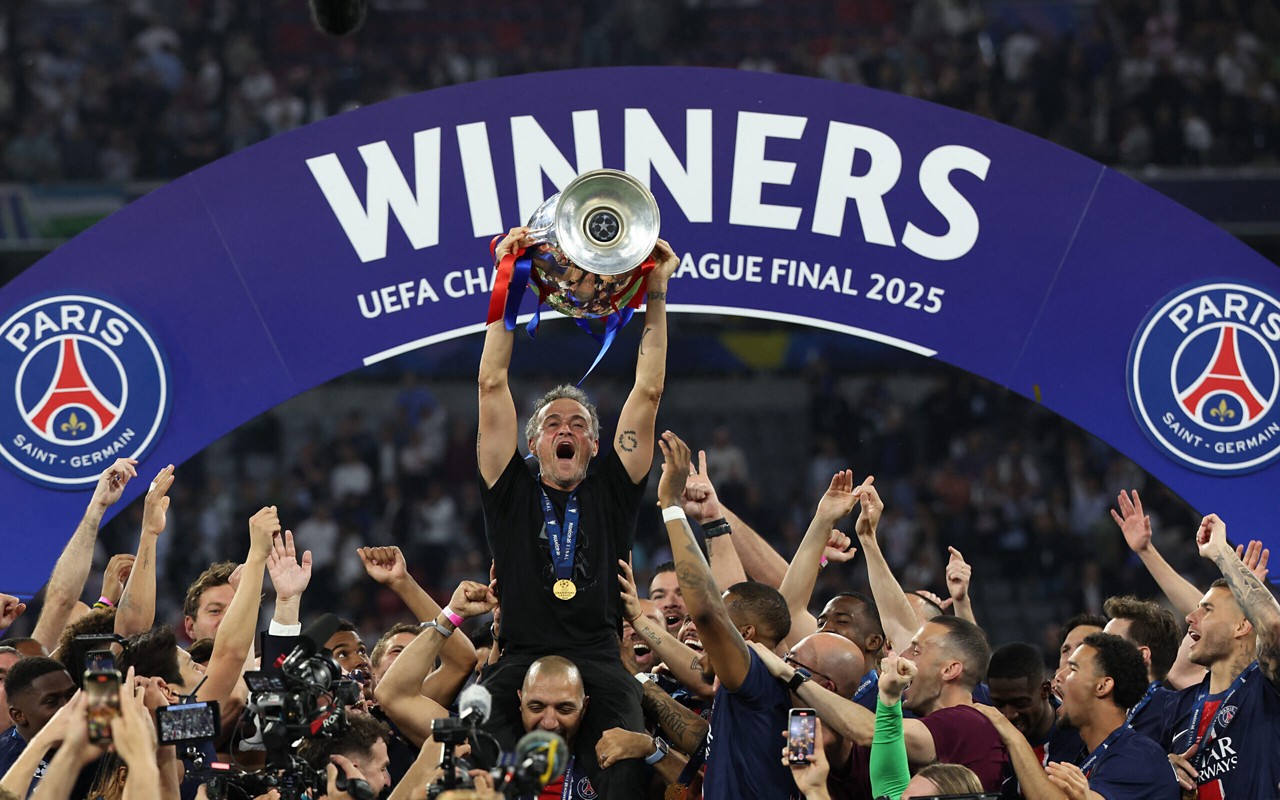 Paris Saint-Germain's Spanish headcoach Luis Enrique lifts the trophy with his players as he celebrates winning the UEFA Champions League final football match between Paris Saint-Germain (PSG) and Inter Milan in Munich, southern Germany, on May 31, 2025. (Photo by FRANCK FIFE / AFP)