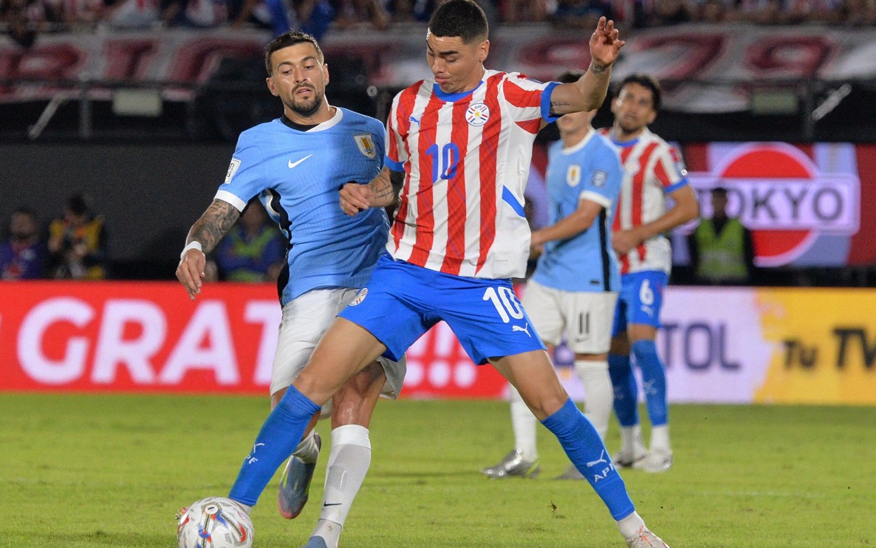 Arrascaeta, do Uruguai, e Almirón, do Paraguai, disputam bola (Foto: DANIEL DUARTE / AFP)