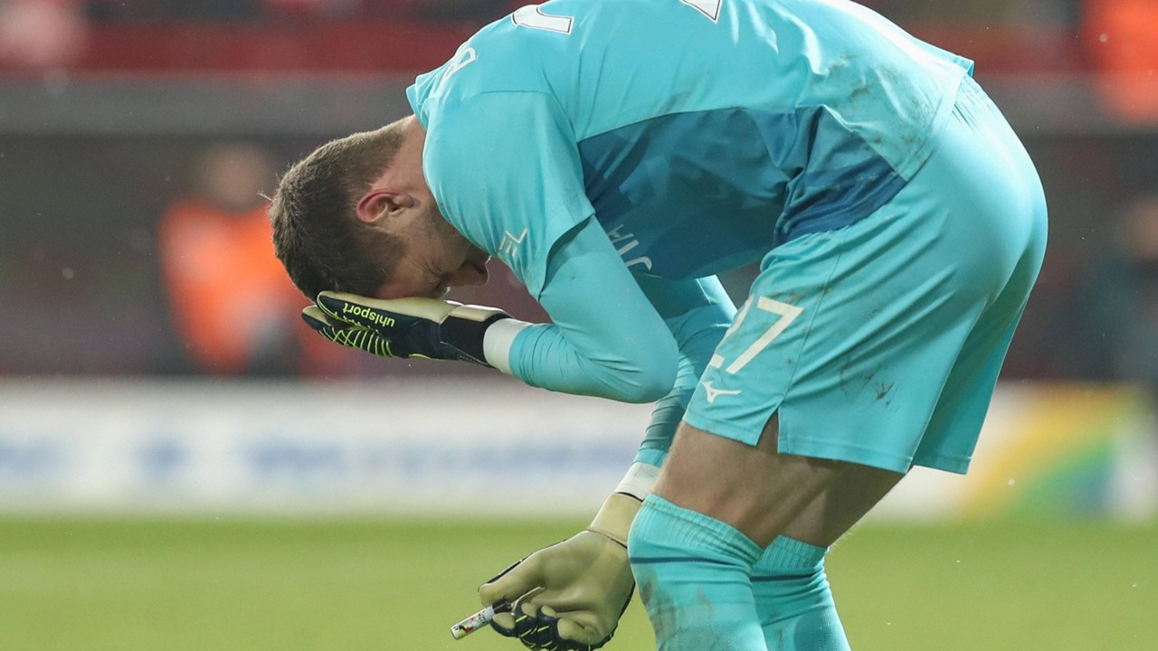 Patrick Drewes, goleiro do Bochum, leva mão ao rosto após ser atingido por isqueiro