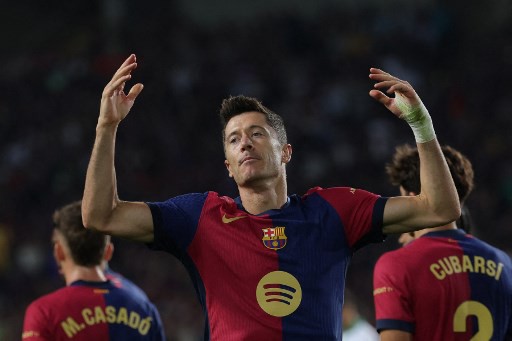 Barcelona's Polish forward #09 Robert Lewandowski celebrates after scoring his team's first goal during the Spanish league football match between FC Barcelona and Getafe CF at the Estadi Olimpic Lluis Companys in Barcelona on September 25, 2024. (Photo by LLUIS GENE / AFP)