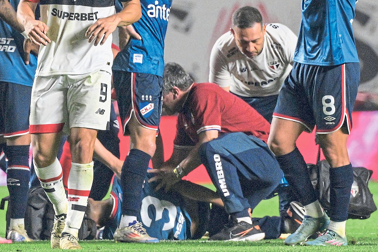 Nacional's defender Juan Manuel Izquierdo receives medical attention after collapsing onto the ground during the Copa Libertadores round of 16 second leg football match between Brazil's Sao Paulo and Uruguay's Nacional at the MorumBIS stadium in Sao Paulo, Brazil, on August 22, 2024. Uruguay's Football Federation suspended its local championship on August 26, 2024, due to the serious health condition of Izquierdo, who is in intensive care in Brazil after suffering a heart attack in the middle of the Copa Libertadores match against Sao Paulo on August 22. (Photo by Nelson ALMEIDA / AFP)