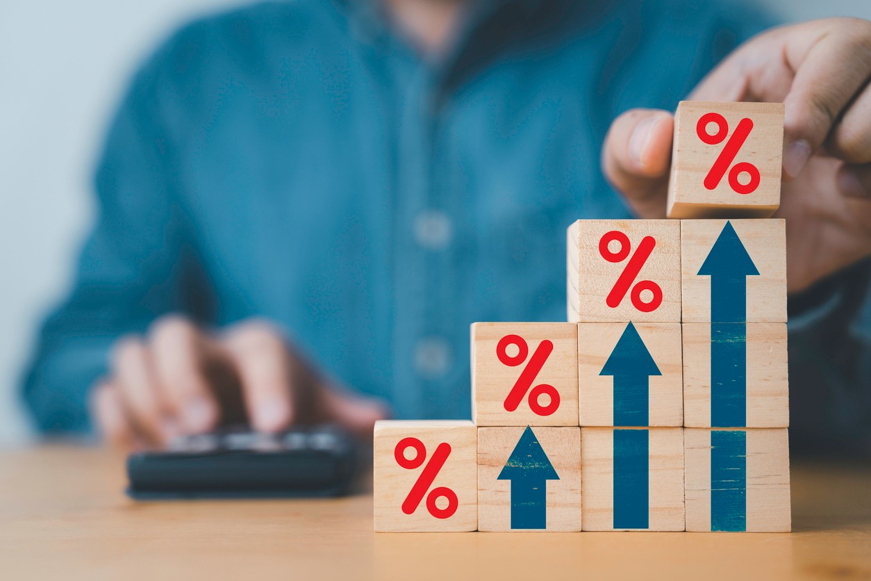 Businessman putting red percentage sign with increa arrow for financial interest rate and business investment growth from dividend concept.