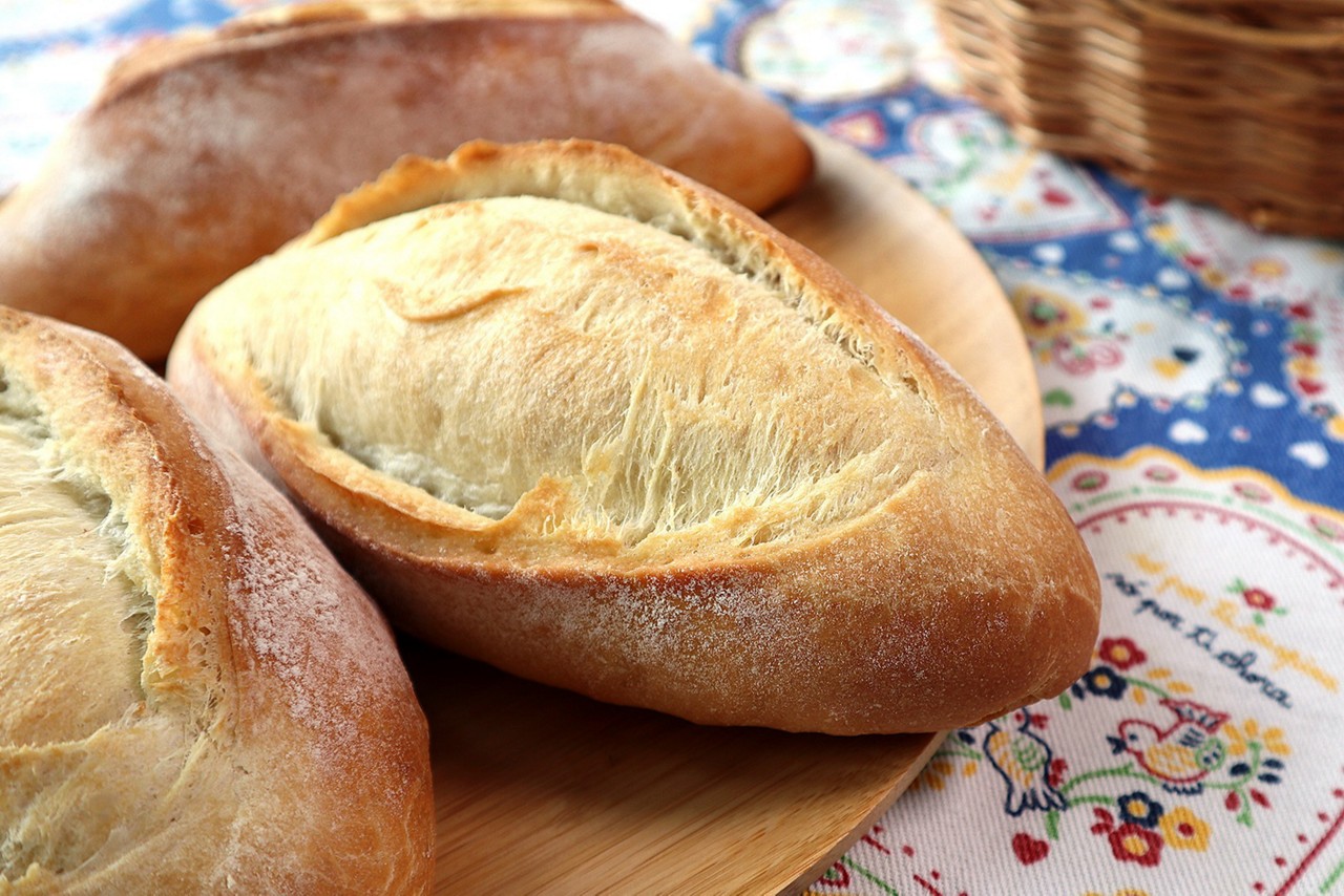 Um pão com um miolo macio, uma crosta crocante, bem amarelinha e polvilhada com farinha: esse é o Pão Português.