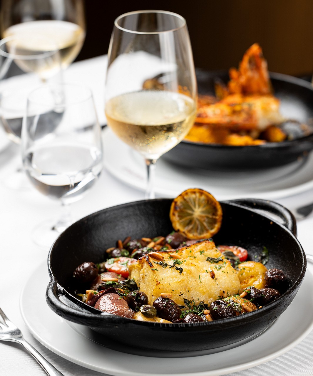 Bacalhau assado a carvão com batatas, cebola, tomate, alcaparras, azeitonas e pinoli (R$ 182) do restaurante Gero