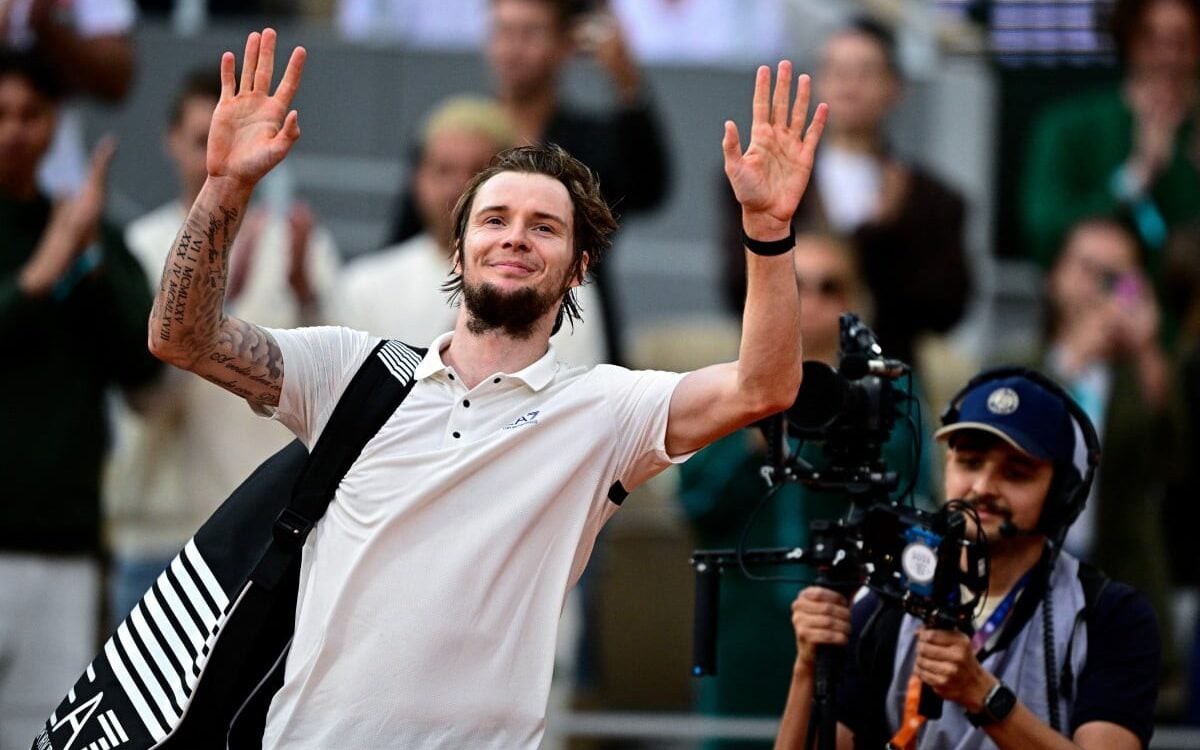 O cazaque Alexander Bublik se despede do público após a derrota para Jannik Sinner em Roland Garros (Foto: JULIEN DE ROSA / AFP)