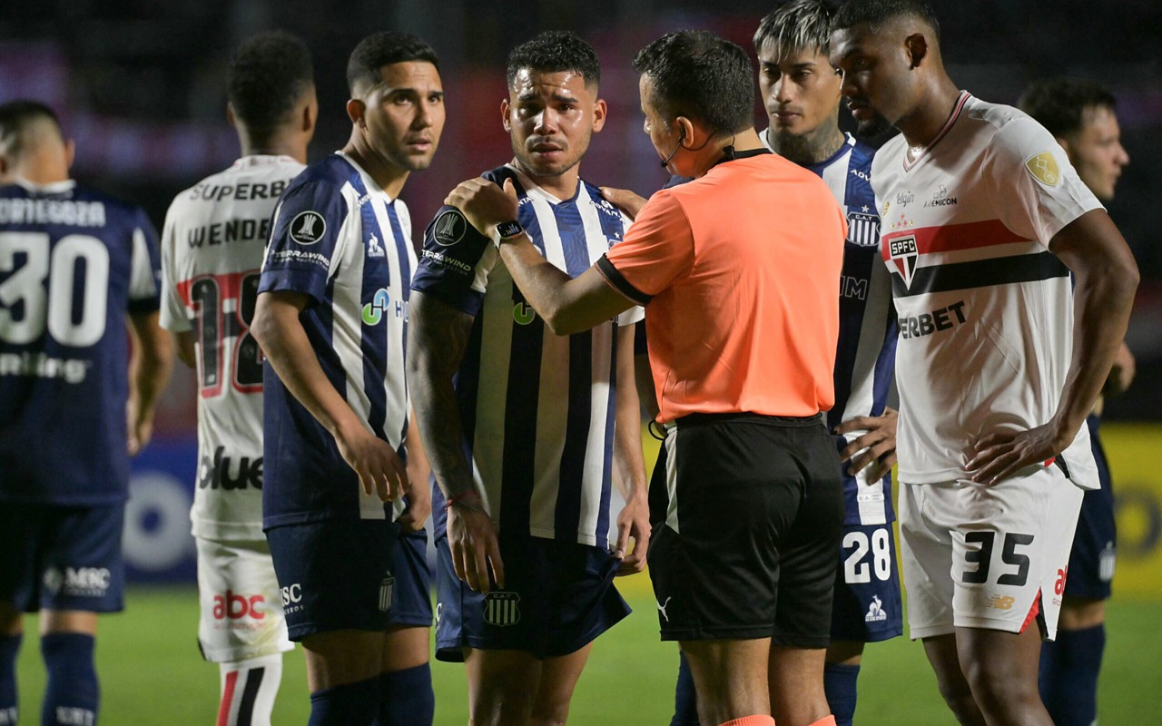 Navarro, do Talleres, conversa com o árbitro Piero Maza (Foto: NELSON ALMEIDA / AFP)