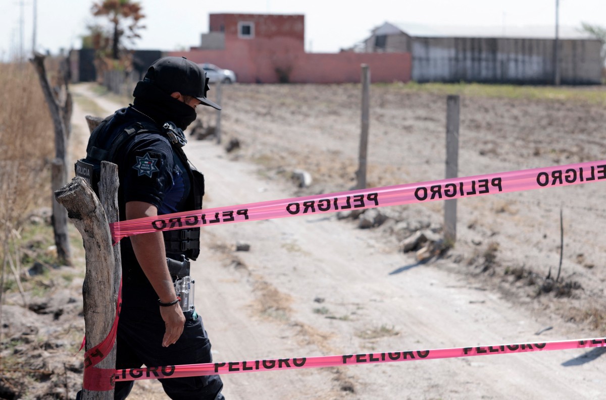 Policial guarda entrada de rancho no estado de Jalisco, México, onde cartéis treinavam seus integrantes (foto ULISES RUIZ/AFP)