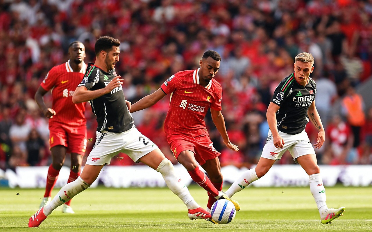 Gravenberch e Merino disputando a bola no duelo entre Liverpool e Arsenal, pela Premier League. (Foto: Peter Powell/AFP)