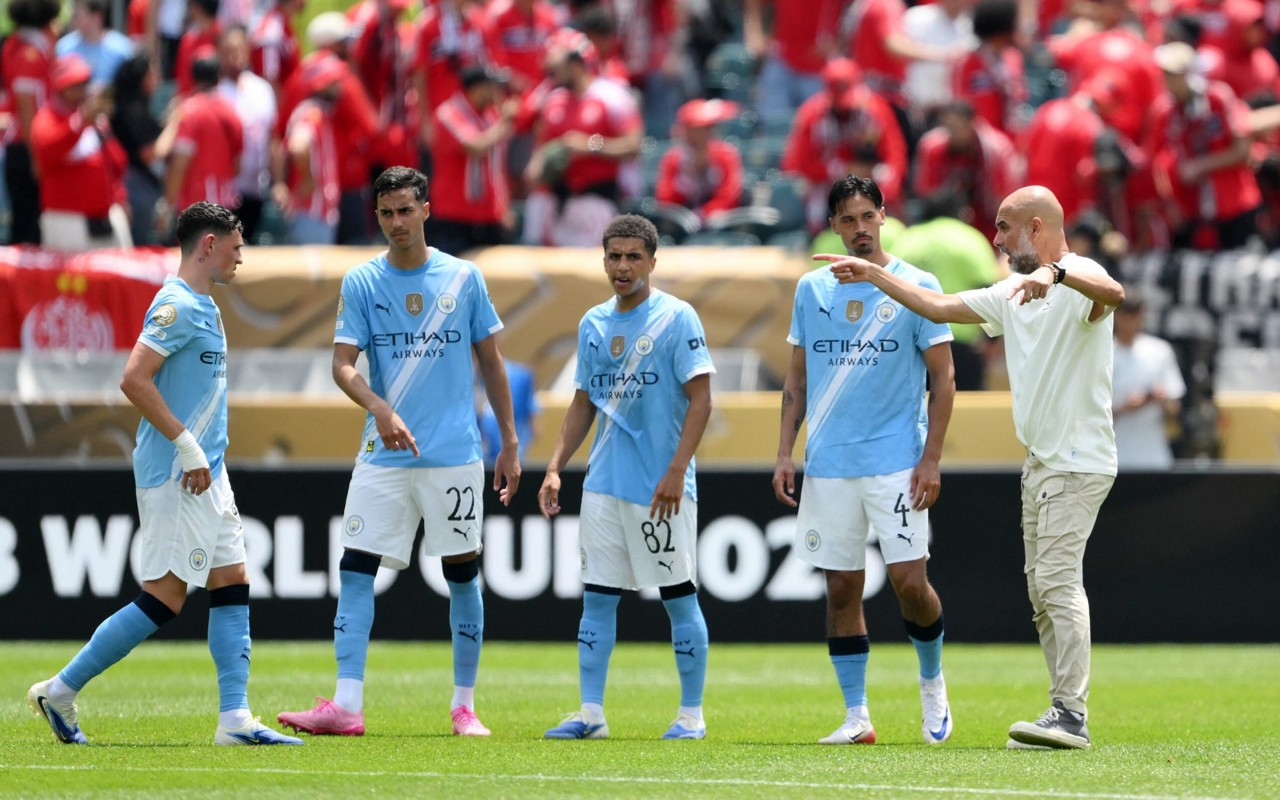 Pep Guardiola mostra para jogadores do Manchester City o posicionamento ideal deles em campo (Foto: David Ramos/Getty Images via AFP)