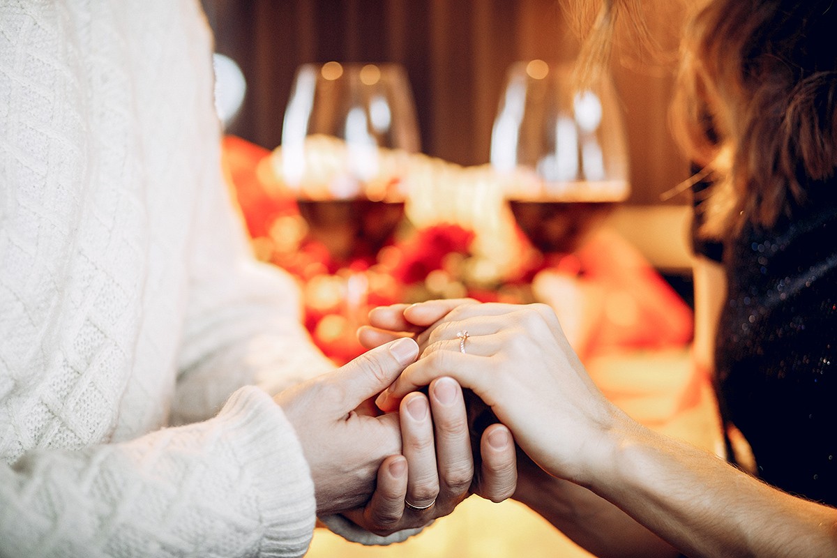 Couple in a restaurant. Lady in a black dress. A man makes a proposal to a woman