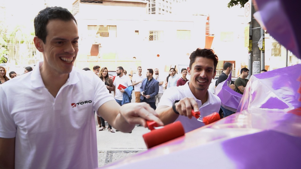Pintando o touro estão Alessandro Chagas, diretor de investimentos do Santander, e do lado direito Geraldo Rodrigues Neto, diretor de pessoa física do Santander.