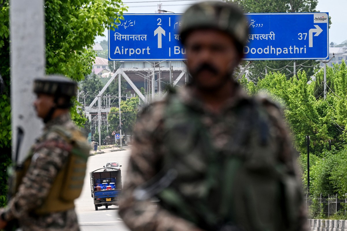 Paramilitares indianos montam guarda em uma rua que leva ao aeroporto internacional de Srinagar, neste sábado (10)