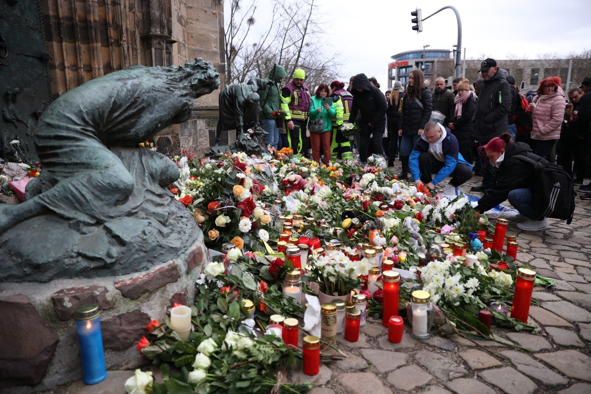Pessoas depositam flores e velas no local de um ataque de atropelamento em um mercado de Natal em Magdeburg, no leste da Alemanha
