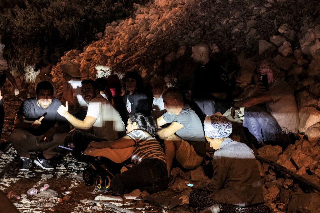 Pessoas se abrigam abaixo de ponte no momento do bombardeio em Israel
