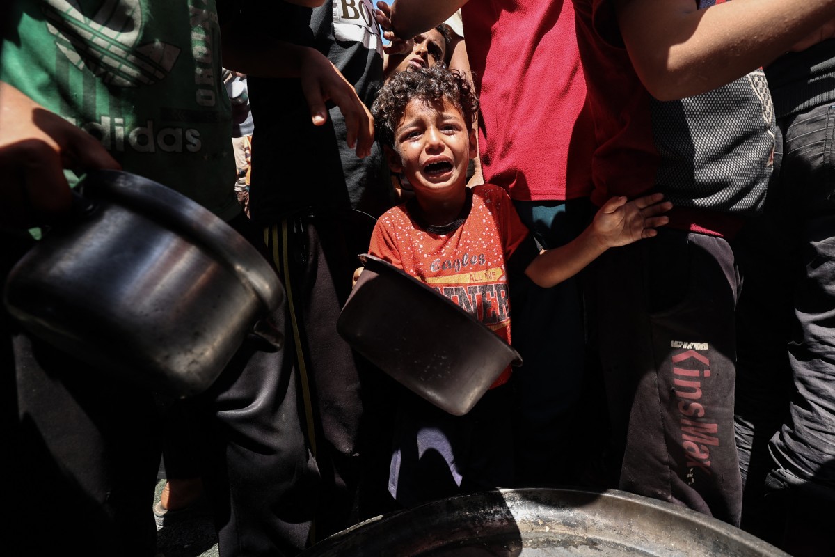 Criança palestina chora na fila por comida no campo de refugiados de Nuseirat, na Faixa de Gaza (Eyad BABA  AFP)