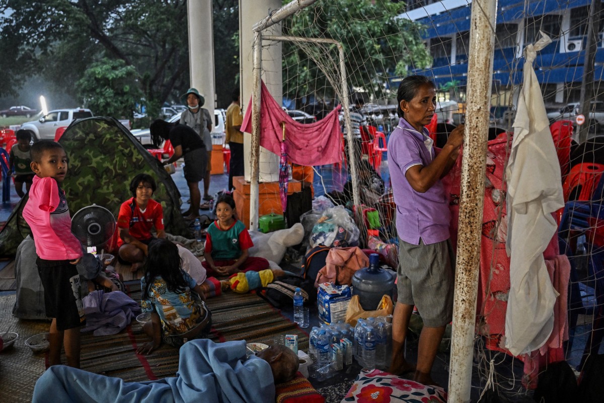 Pessoas deslocadas pelo conflito em curso entre Tailândia e Camboja descansam em um centro de evacuação na província de Si Sa Ket, na Tailândia