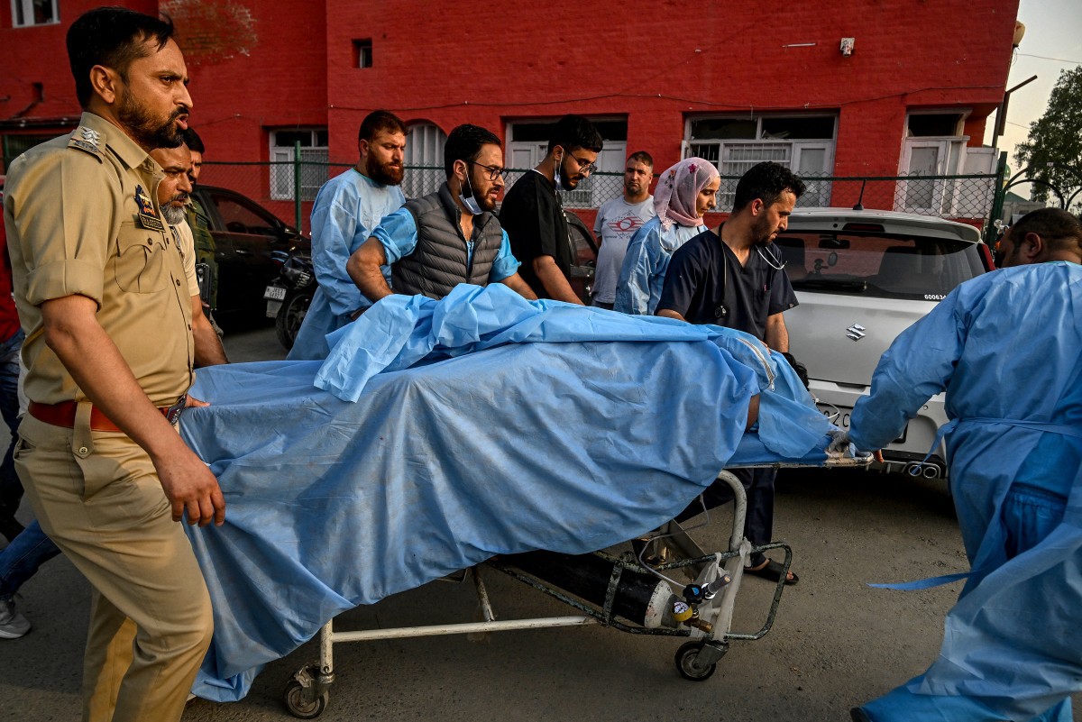 Policiais e paramédicos carregam vítima até um hospital em Anantnag