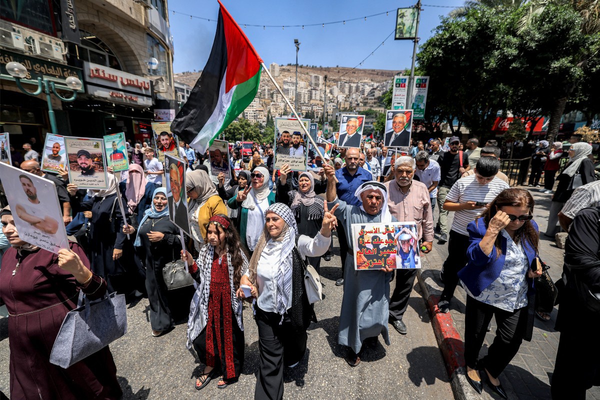 Manifestantes gritam slogans enquanto marcham em um protesto em solidariedade ao povo da Faixa de Gaza e aos detidos palestinos na cidade ocupada de Nablus, na Cisjordânia