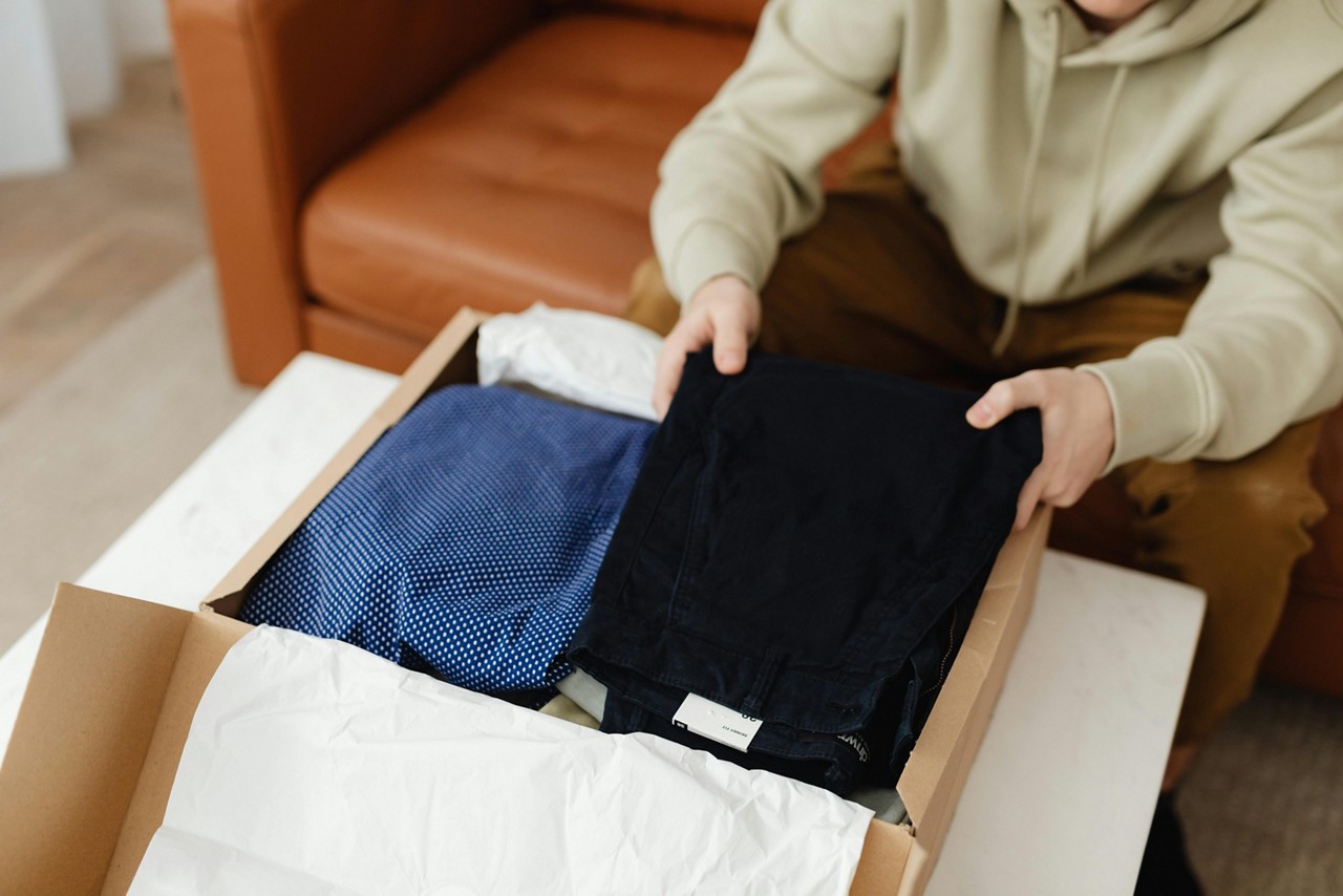 Imagem ilustrativa de uma pessoa que recebeu roupas pelos Correios