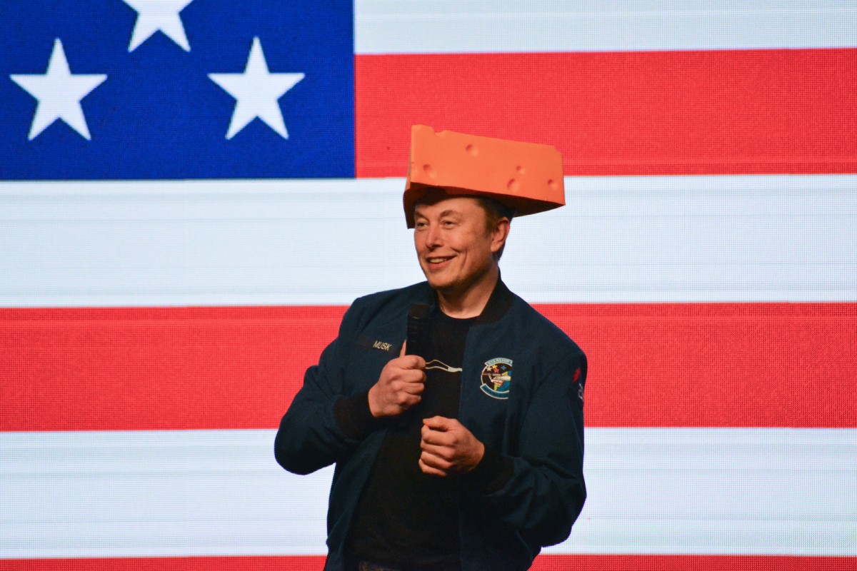 Elon Musk, com chapéu de queijo, durante evento político no Wisconsin