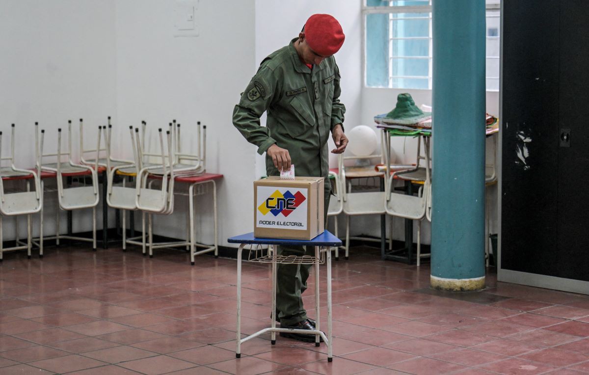Um membro da Guarda de Honra Presidencial deposita seu voto em uma seção eleitoral durante as eleições municipais em Caracas, neste domingo (27)