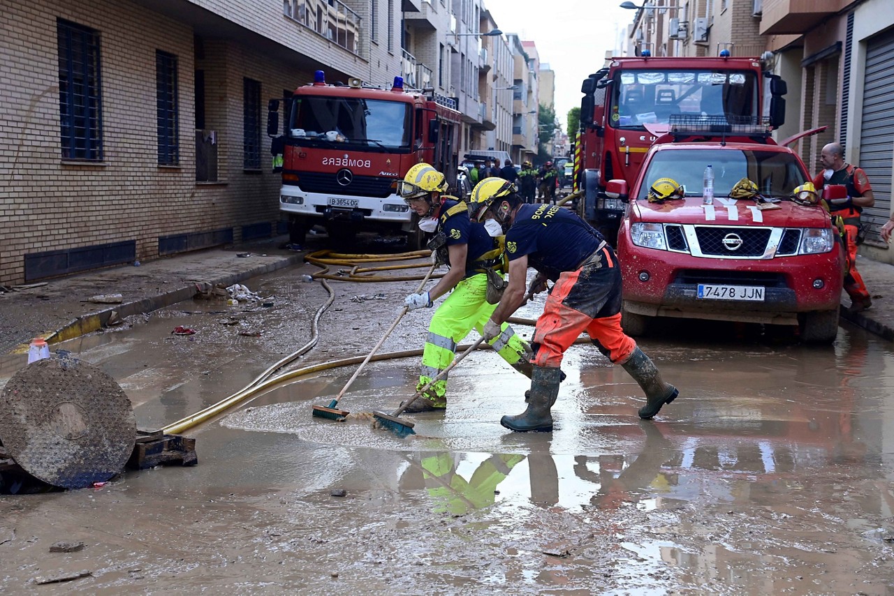 Bombeiros limpam uma rua lamacenta em Sedavi, ao sul de Valência, leste da Espanha