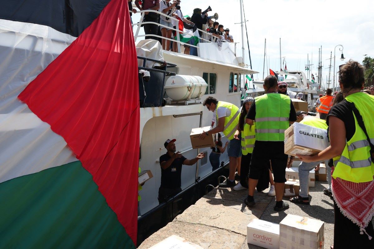 Ativistas carregam um barco antes da partida da flotilha destinada a romper o bloqueio israelense à Faixa de Gaza, na Espanha